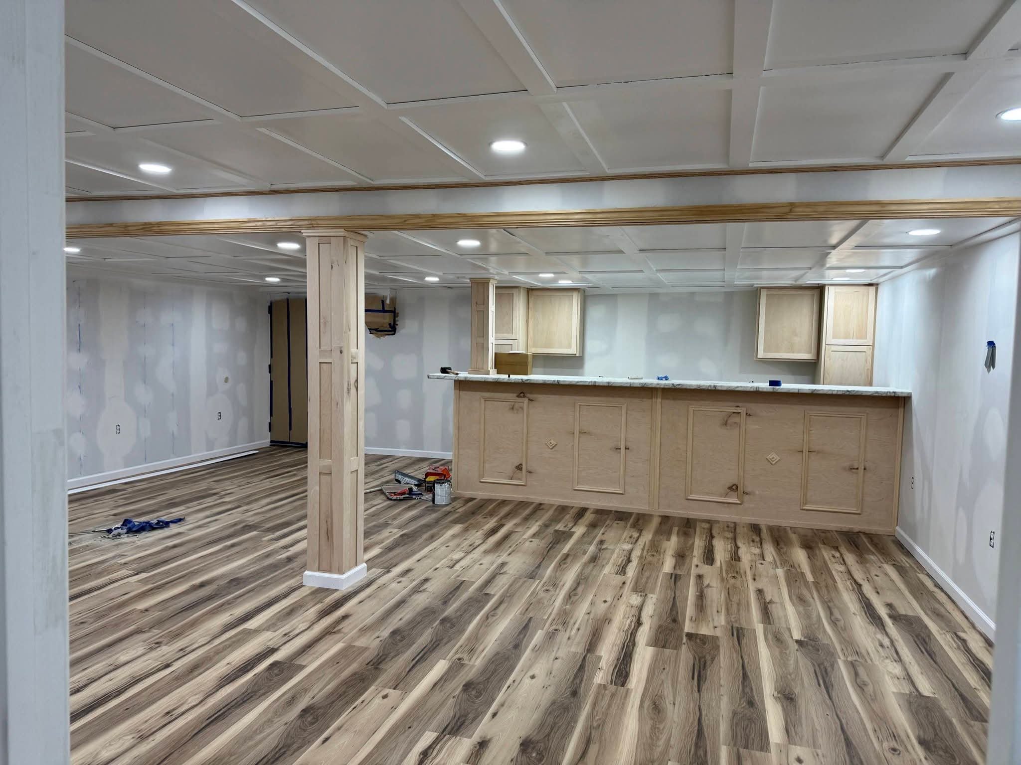 Basement remodel with new flooring, coffered ceiling and custom bar